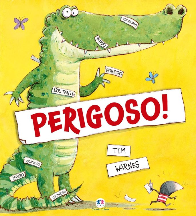 Capa do livro Perigoso: mostra um crocodilo em pé sobre duas patas, com a etiqueta “PERIGOSO!” em letras grandes e vermelhas no meio. Uma toupeira está fugindo dele, segurando etiquetas e um lápis.